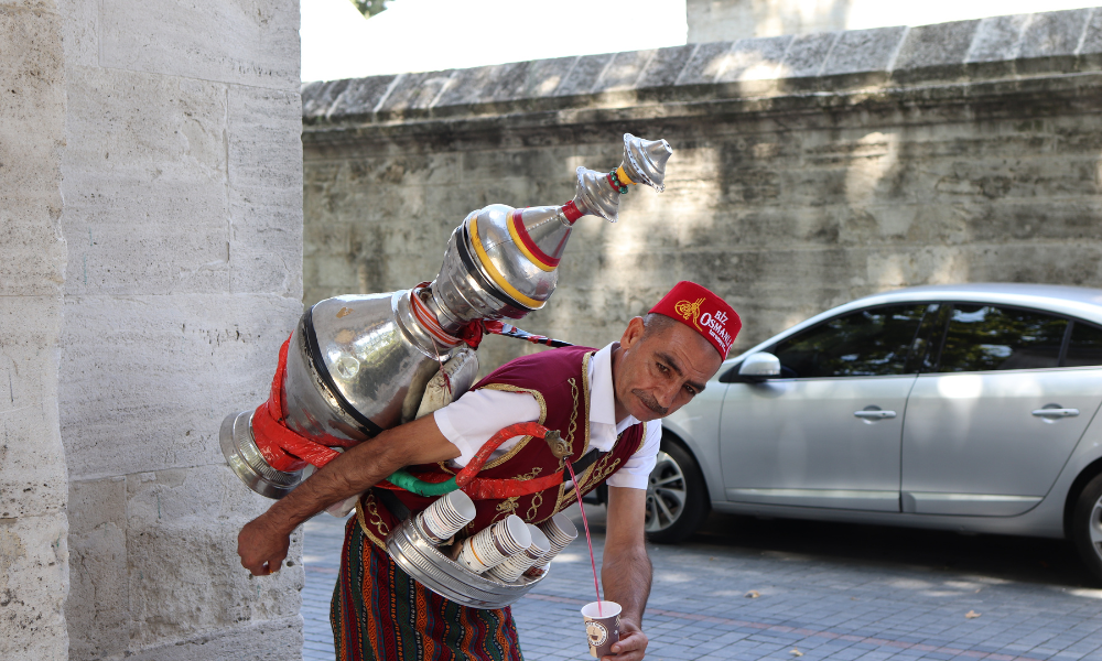 A sherbet seller in Istanbul in traditional gear with a beautiful red and gold cap and sash