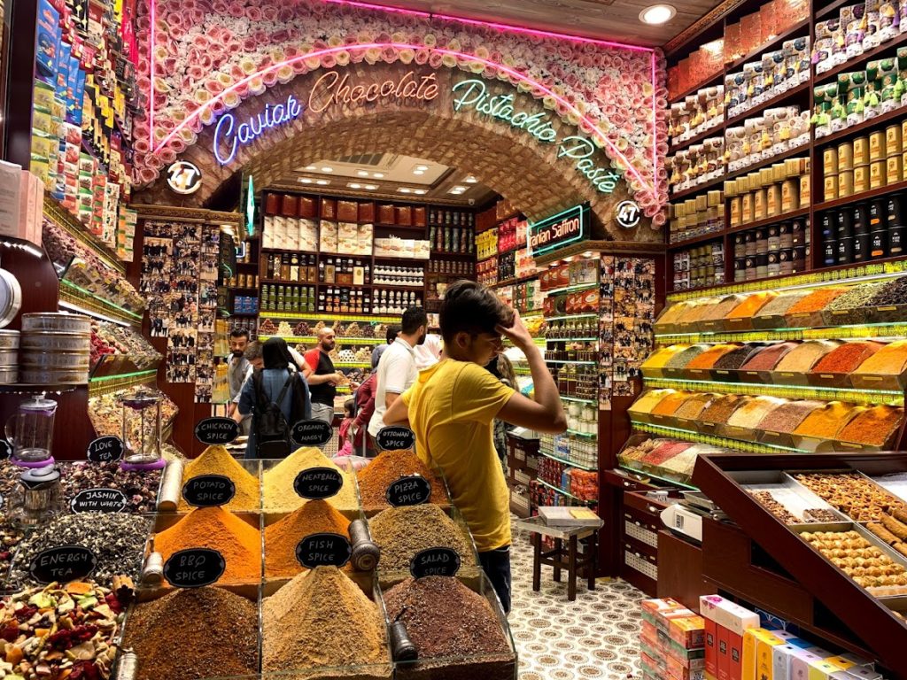 You can see an array of colour shops, an interior pink ornate façade, mounds of spices, and sales boy in the middle of the shop. Some of the spices/masalas have labels on them - salad spice, fish spice, Indian saffron, and all.... 