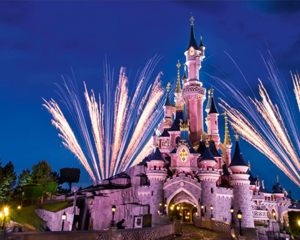 The iconic castle at Disneyland Paris, all beautiful and the sky lit up with fireworks and lights displays. A perfect place to head for your family break. 