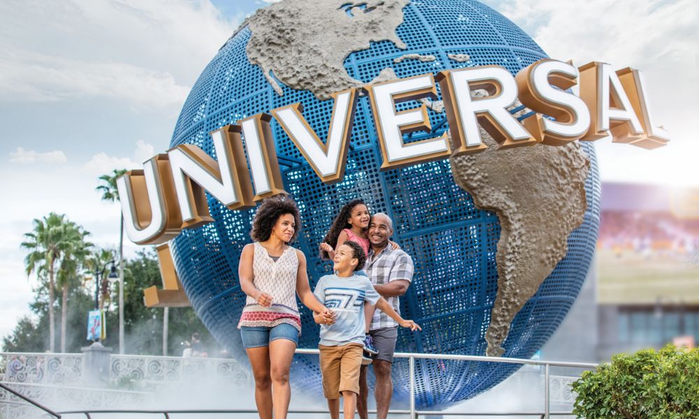 The iconic blue globe with the word 'Universal' written on it in caps, and in the front is a family of mother, father, daughter and son all happy with their Orlando holiday offer