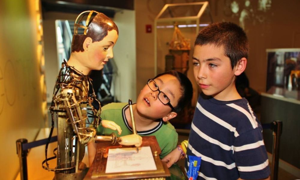 Two children inside the Franklin Institute in Philadelphia and they are looking at Maillardet's Automaton