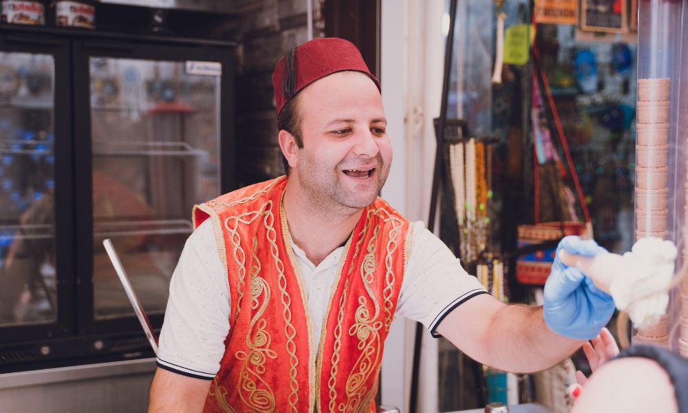 A man in a traditional costume hands out Turkish ice cream in Turkey