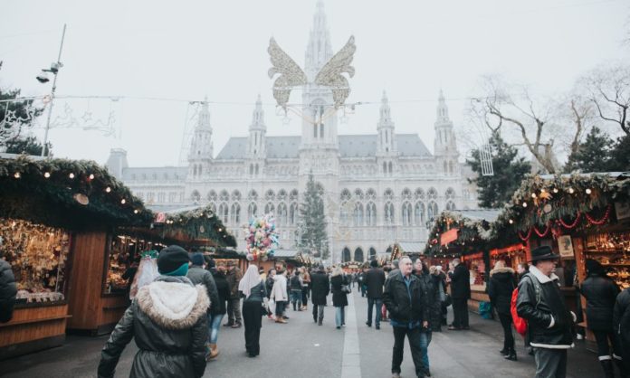 Shows Vienna during Christmas with its iconic buildings, snow and festivities and people