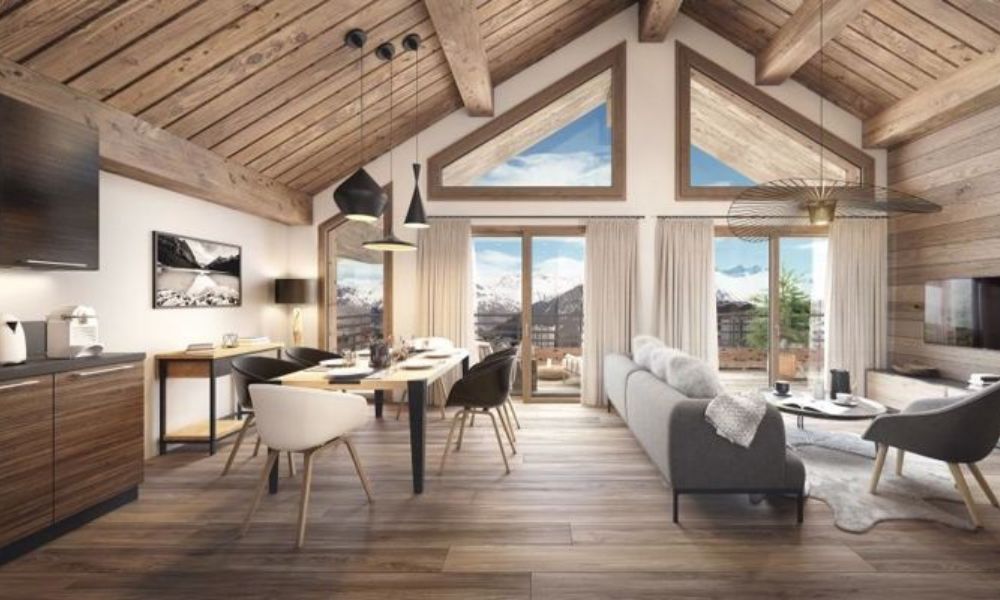 An interior of a property in French Alps, ideal for ski enthusiasts and shows wooden flooring, nice, warm interiors and you can see the Alps from the living room