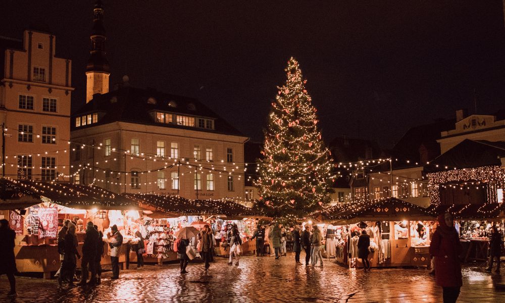 How cities look during Christmas in Europe - shows a lit up x-mas tree, stalls, Christmas markets and crowds