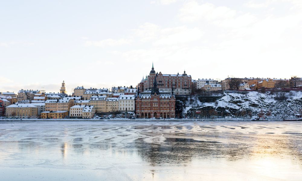 Stockholm during Christmas shows snow topped houses, buildings and frozen body of water