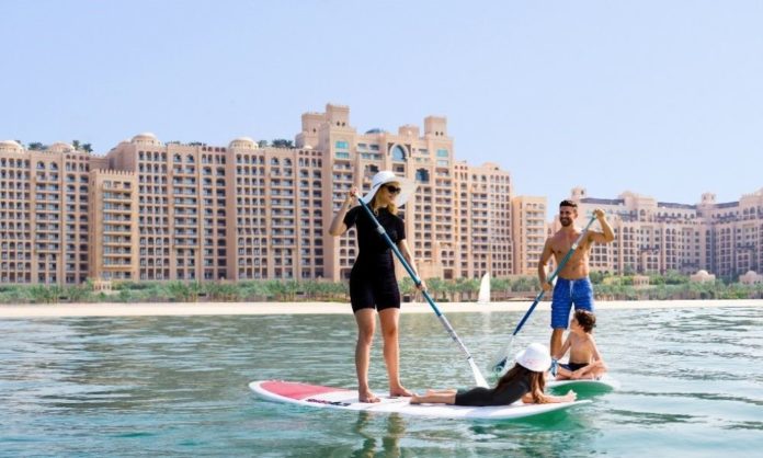 A family on paddle boats in the ocean in Dubai - a representative pic from Emirates