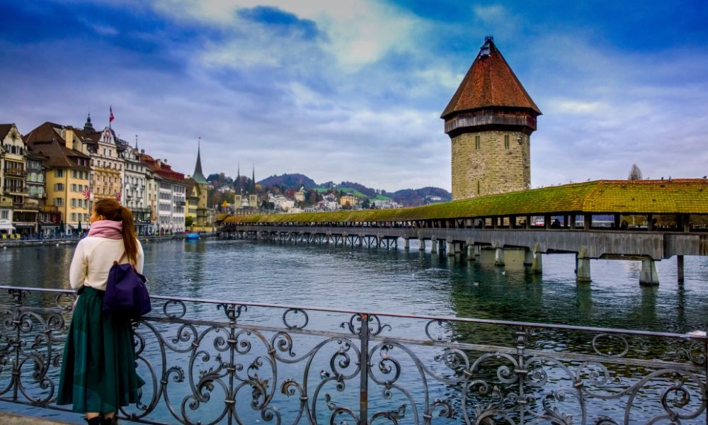 Woman Standing Against Handrails Beside Body of Water in Switzerland