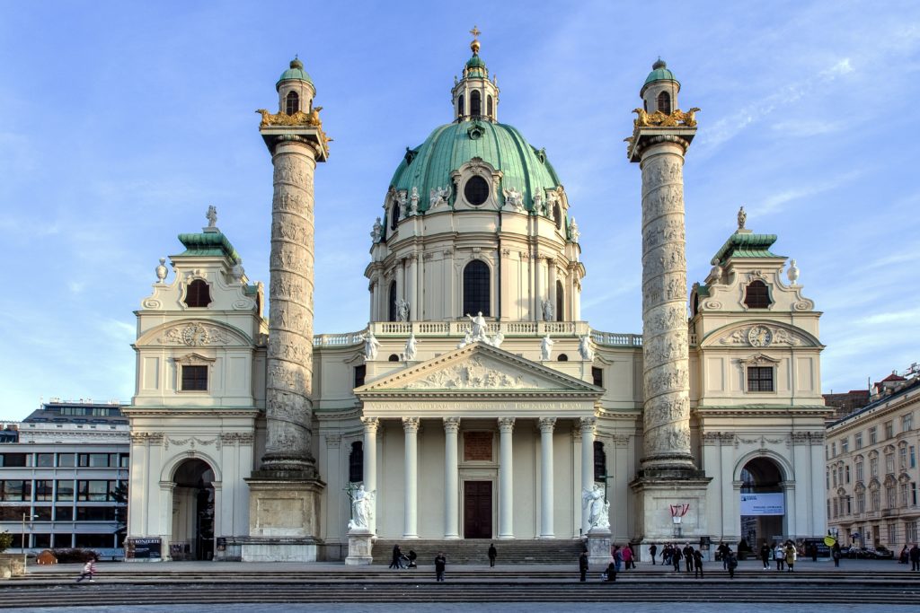 A church-like building with a dome embellished in green and two little dome like structures on two towers/minarets - In Vienna, Europe