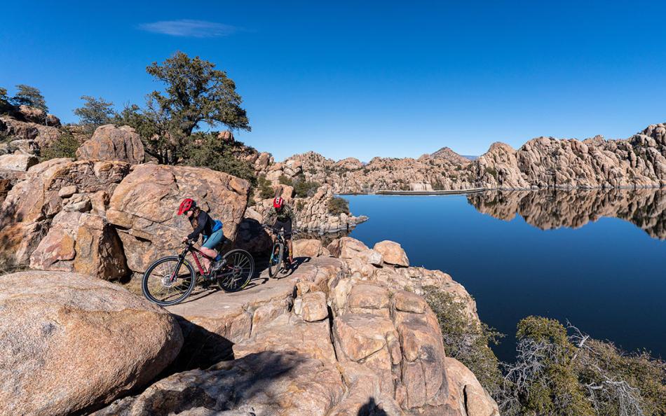 Two people on bikes in the rocky terrains of Arizona
