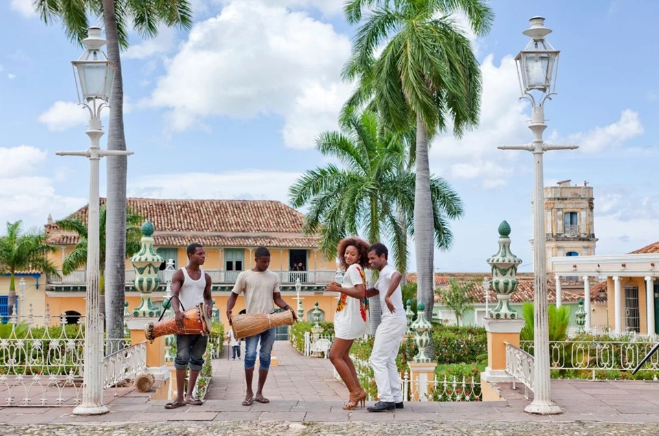 A scene from Cuba with locals playing musical instruments and dancing